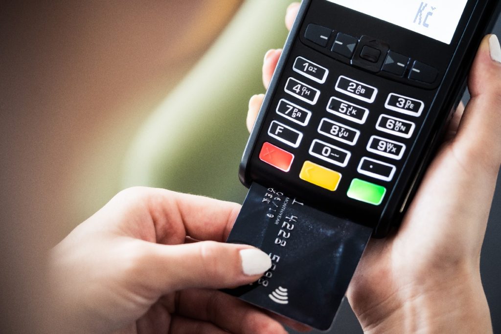 Persona introduciendo su tarjeta para pagar en una terminal de pagos o datáfono